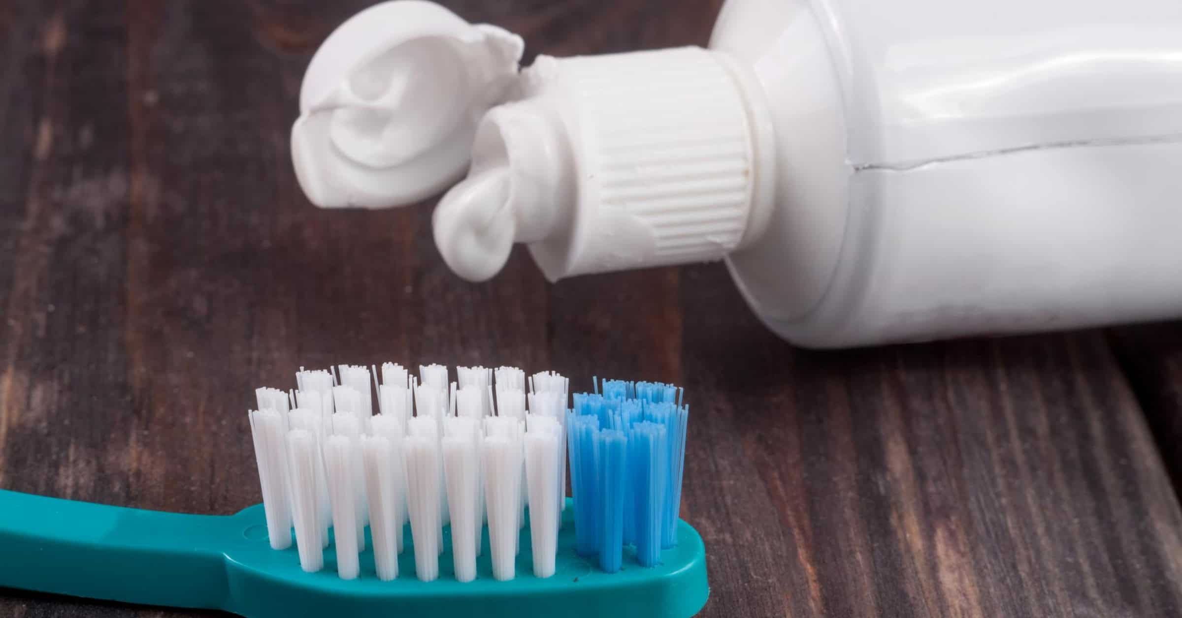 fluoride-free toothpaste and a regular toothpaste side by side on a black table